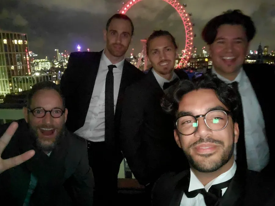 Lorenz and four colleagues in black tie on a rooftop in London, the London Eye lit behind them. A hand-drawn arrow labelled me points to Lorenz, second from the left.